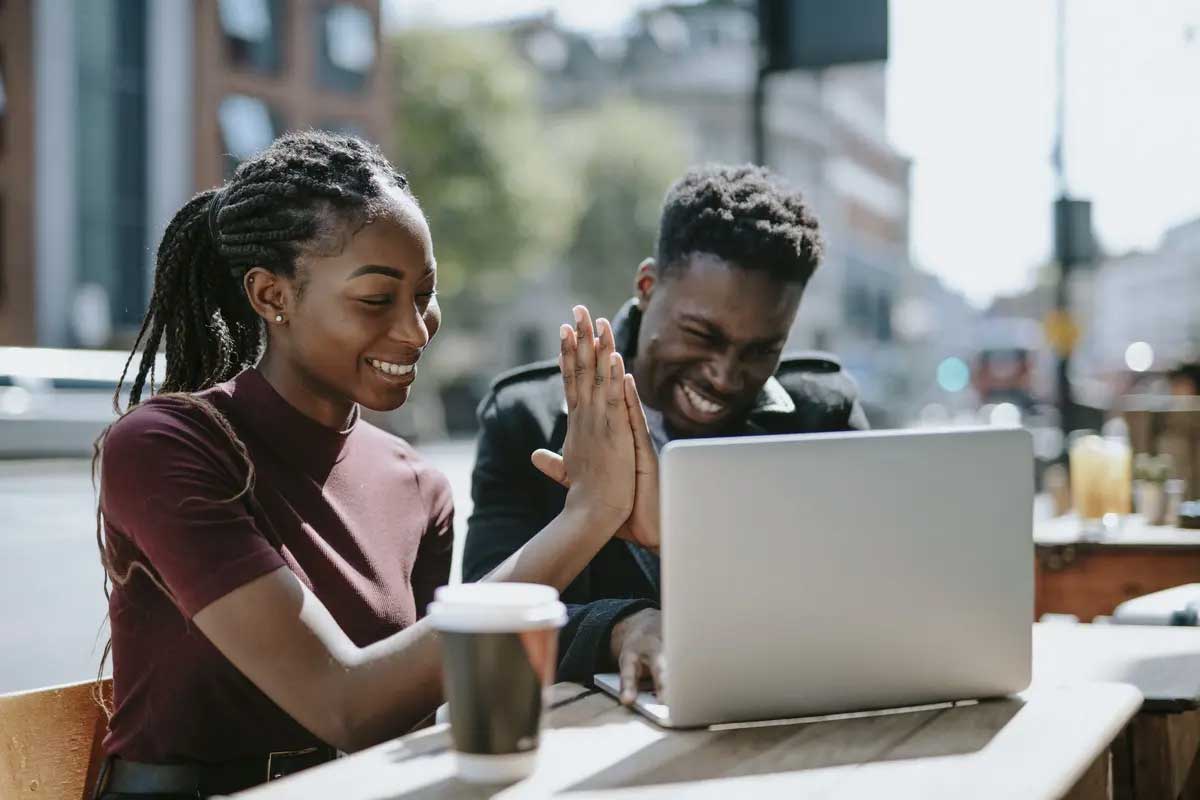 Two students working on laptop