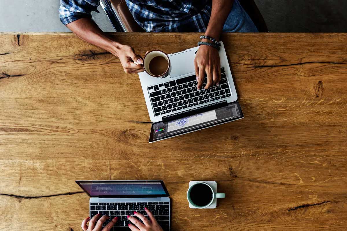 Overhead view of coffee and laptops