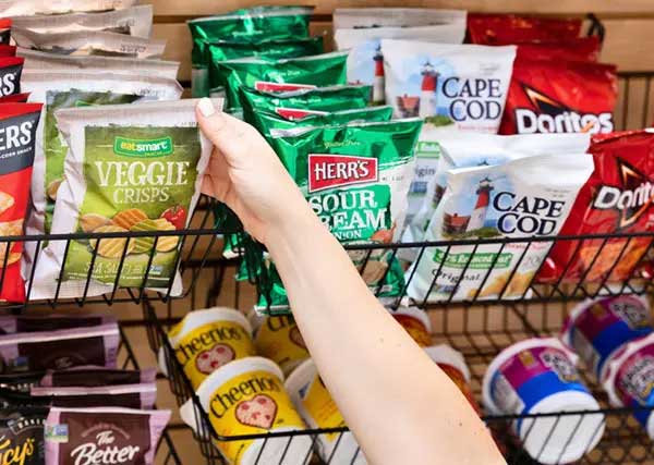 Hands reaching for bag of chips